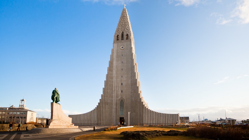 Den sreget utformade Hallgrimskirkja i Reykjavik, i gr sten mot en blekbl himmel.